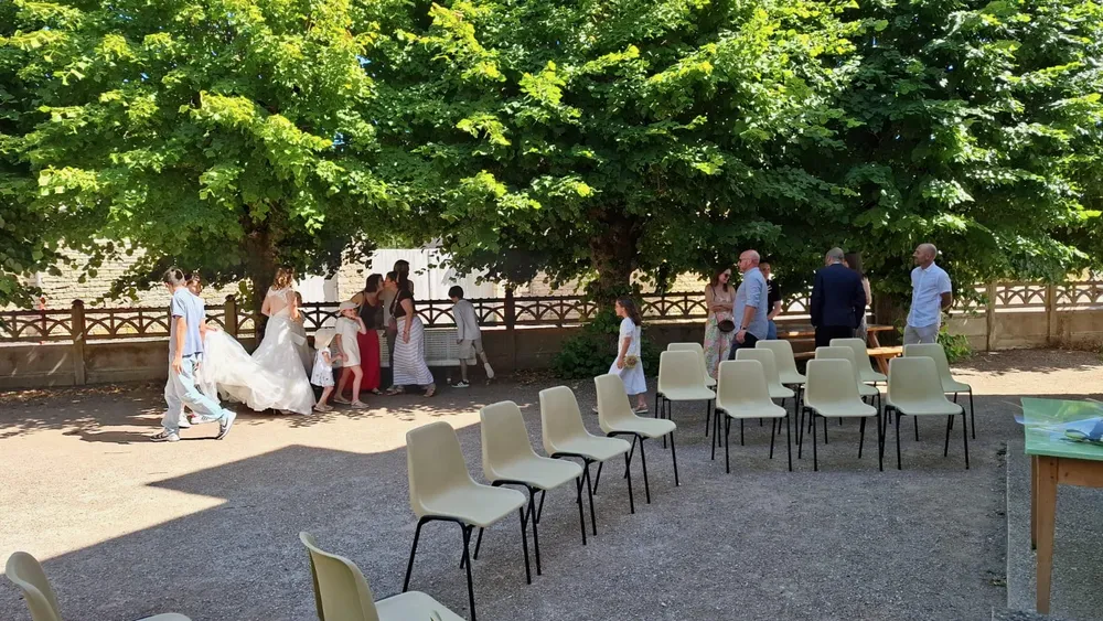Des chaises installées en rangées sous les grands arbres avant la cérémonie.
