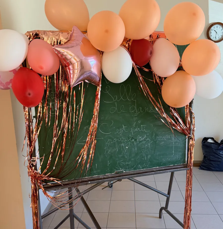 Un tableau d’école décoré de ballons et de guirlandes pour la fête.